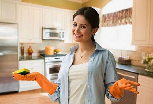femme dans la cuisine portant des gants en caoutchouc