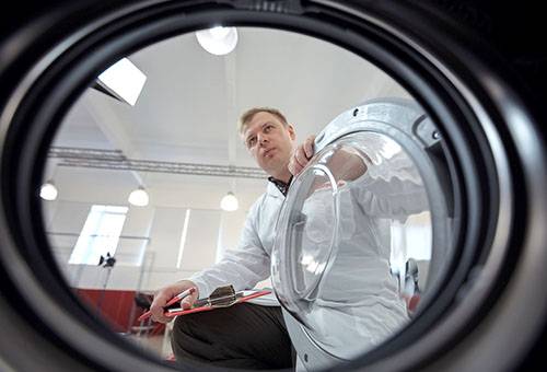 Homme examinant une machine à laver