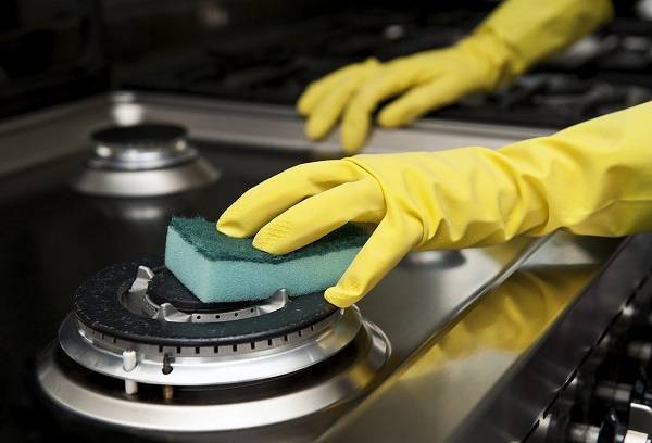 femme nettoyant la cuisinière