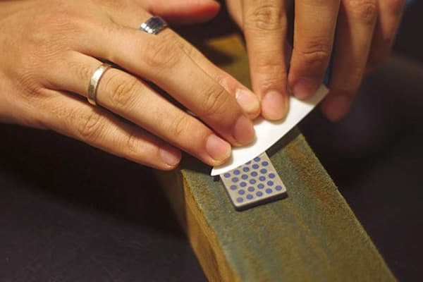 Aiguiser un couteau en céramique sur une pierre à aiguiser
