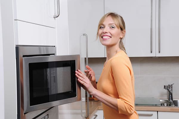 La fille ouvre le micro-ondes
