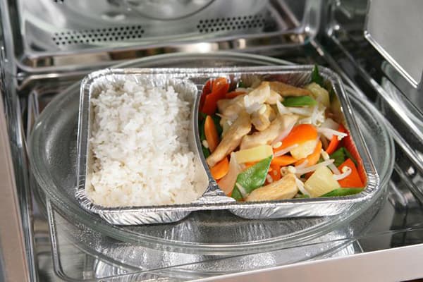 Aliments dans un récipient en aluminium au micro-ondes