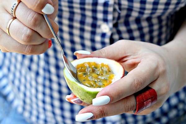 Femme mangeant des fruits de la passion