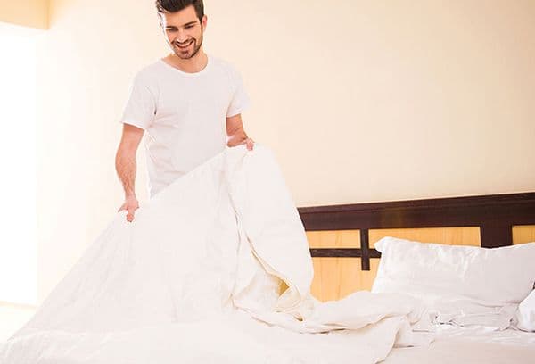 homme faisant le lit