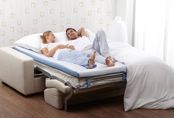 Couple allongé sur un surmatelas correcteur