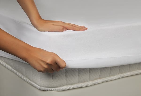 Fille mettant un surmatelas