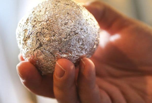 boule de papier aluminium à la main