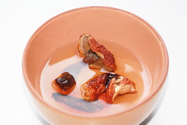 Champignons séchés dans un bol d'eau