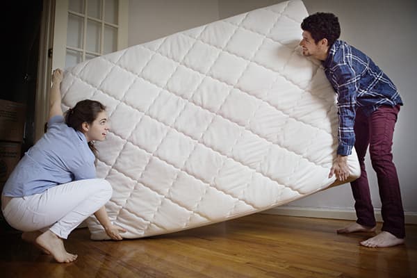 Couple portant un nouveau matelas