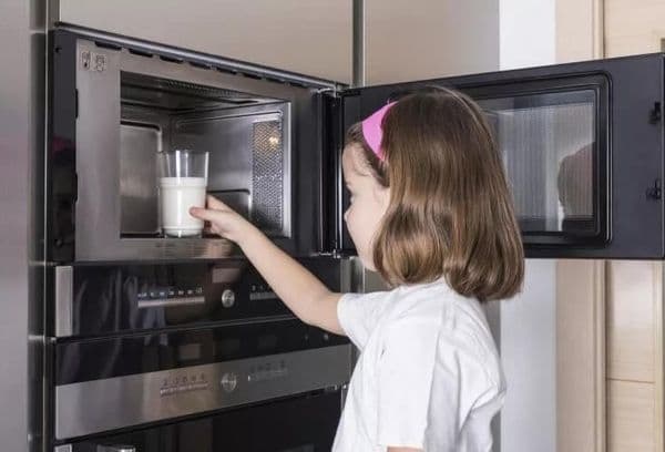 Fille réchauffant le lait