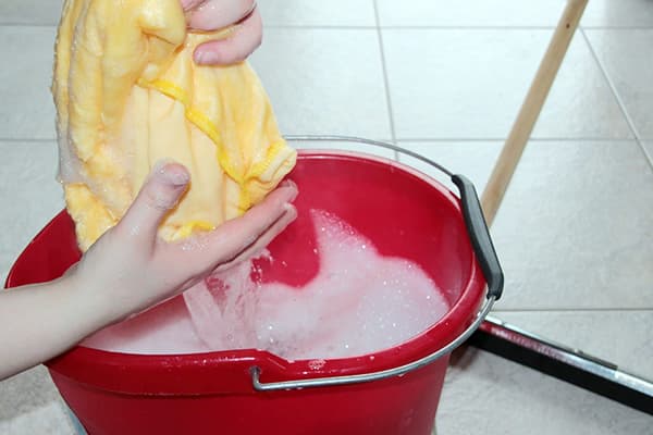 Femme essorant un chiffon avant de se laver