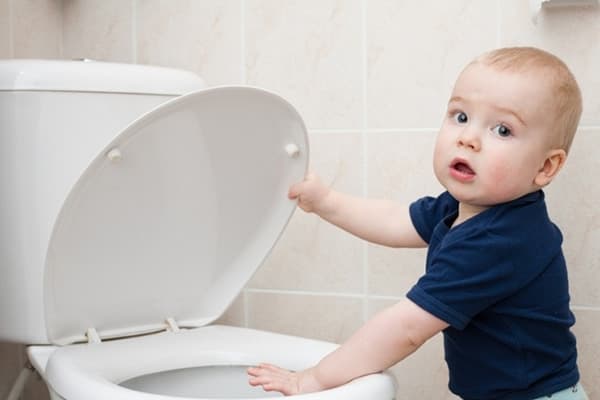 L'enfant a soulevé le couvercle des toilettes