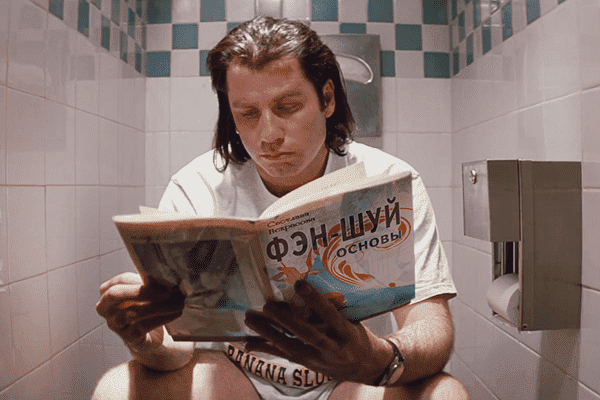 John Travolta lisant un livre sur le feng shui