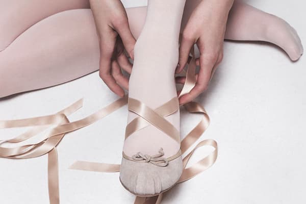 La fille met des chaussures de ballet de danse
