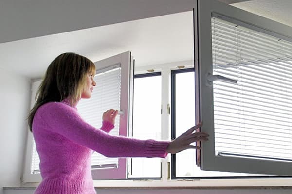 La fille ouvre la fenêtre pour la ventilation