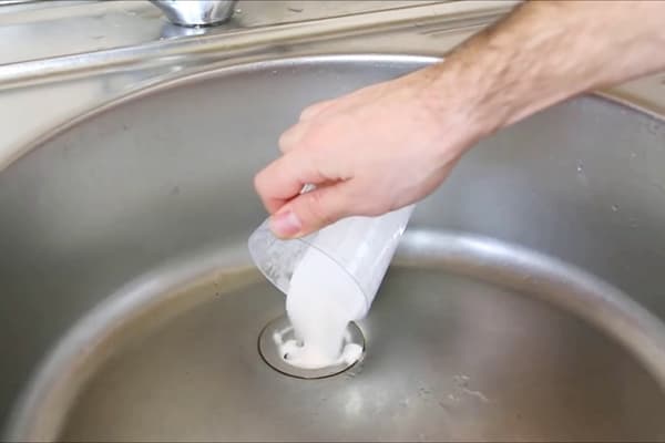 Verser du bicarbonate de soude dans le drain de l'évier