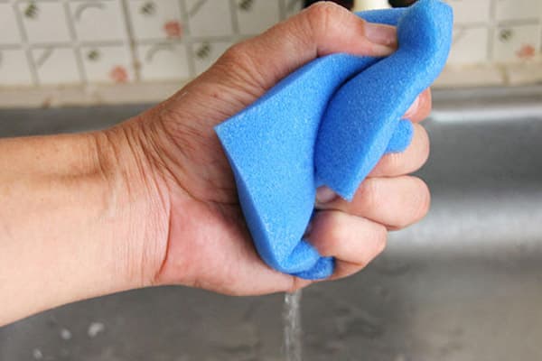 Un homme essore une éponge en mousse