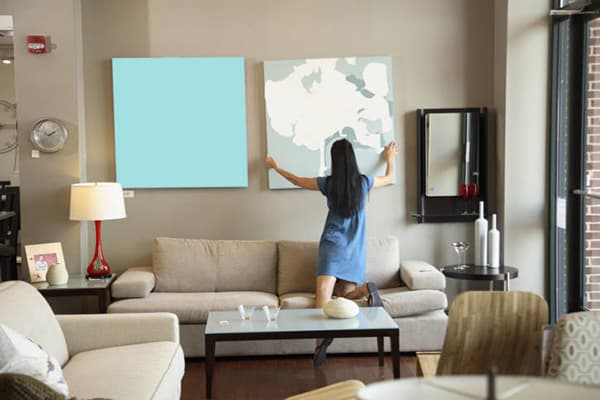 Une fille enlève un tableau du mur