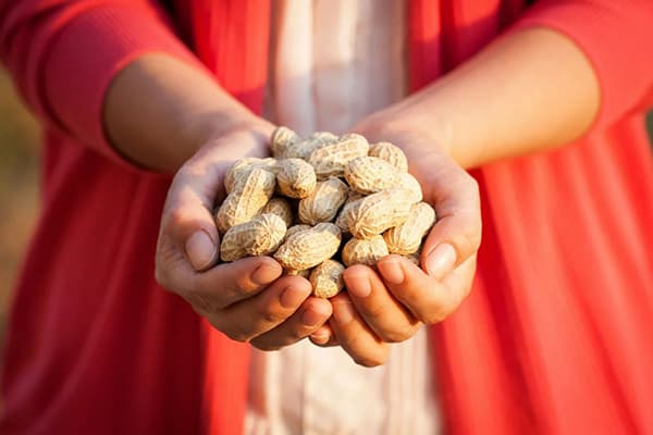 Femme avec une poignée de cacahuètes