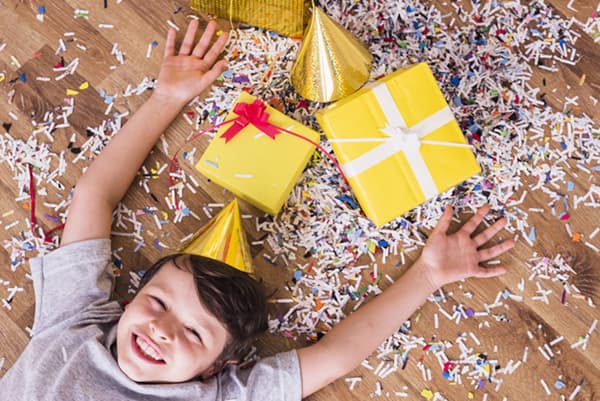 Enfant avec des cadeaux et des confettis