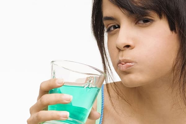 Fille utilisant un bain de bouche