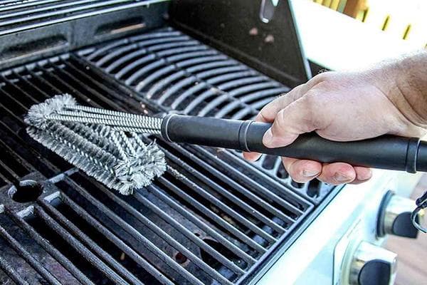 Homme nettoyant le gril