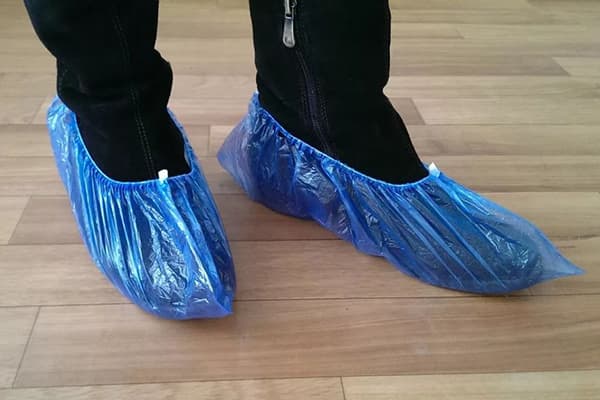 Couvre-chaussures aux pieds