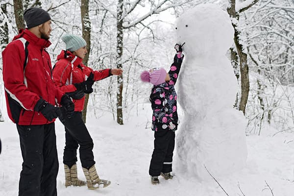 Famille faisant un bonhomme de neige