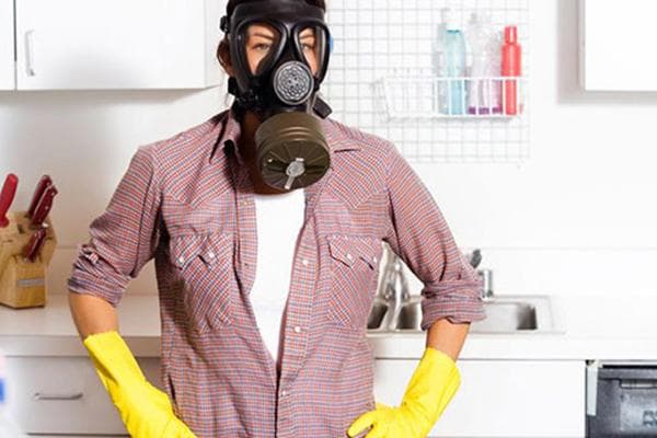 Homme dans un masque à gaz dans la cuisine