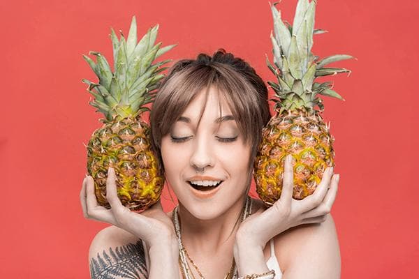 Fille avec deux ananas