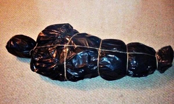 Arbre de Noël enveloppé dans des sacs poubelles noirs