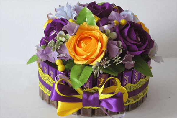 Bouquet de fleurs et de bonbons dans une boîte