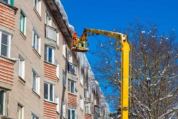 Nettoyer le toit de la neige d'un ascenseur automoteur