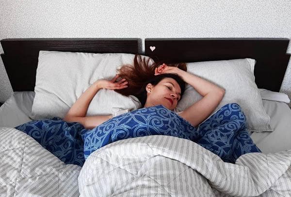 Fille au lit avec des draps clairs