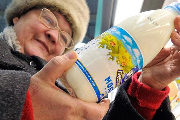 Un retraité choisit du lait dans un magasin