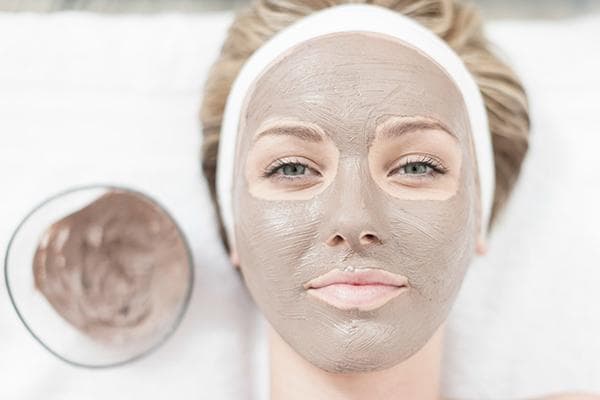 Fille avec un masque cosmétique sur le visage