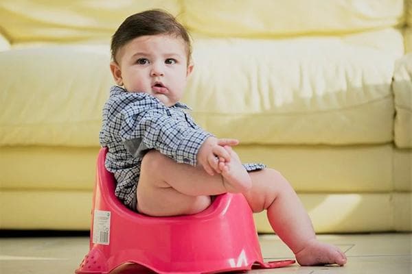 Enfant sur le pot près du canapé