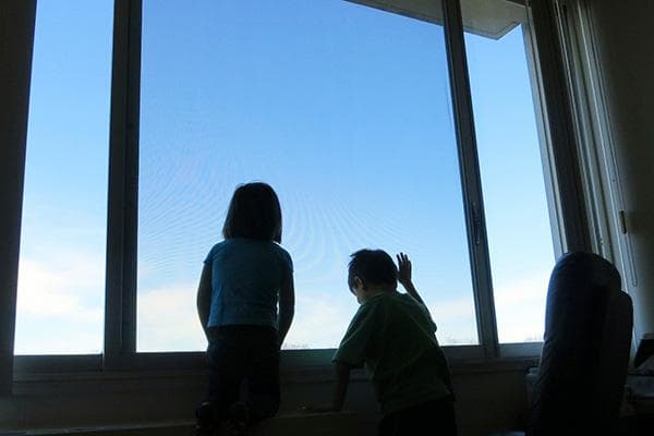 Enfants à la fenêtre en étage élevé