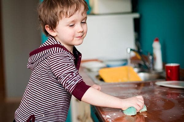 Enfant rangeant la cuisine