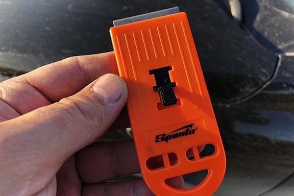 Grattoir pour enlever la peinture du verre