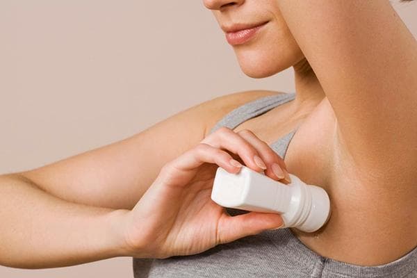 Fille appliquant un antisudorifique