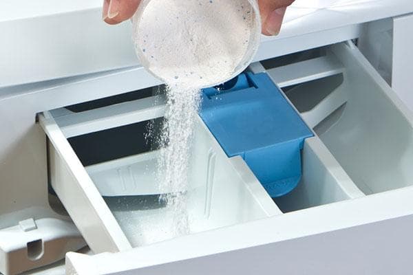 Verser de la lessive dans le bac de la machine à laver