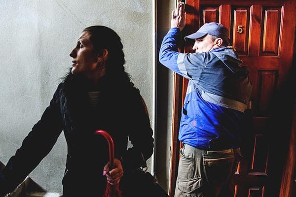 Un employé du Code criminel sonne à la porte de l'appartement