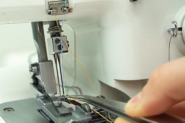 Enfiler une aiguille surjeteuse avec une pince à épiler