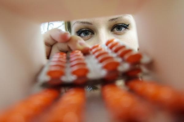 Une fille vérifie la date de péremption des pilules