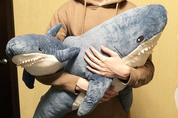 Homme avec des requins en peluche d'IKEA