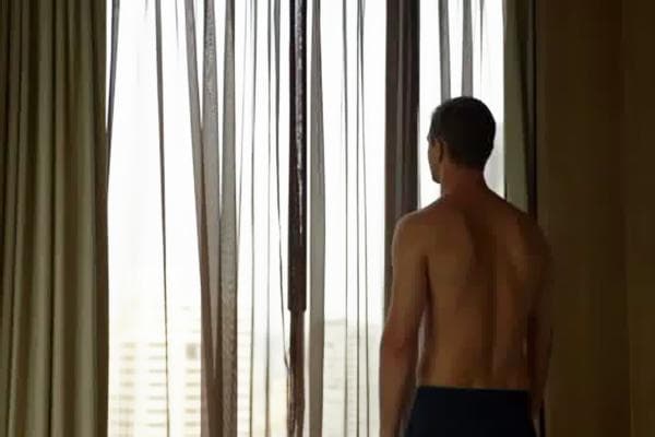 Homme regardant les rideaux