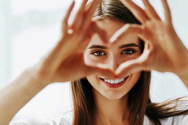 La fille montre un coeur fait des doigts