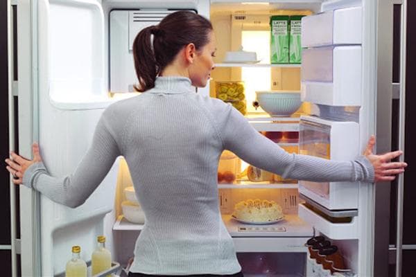 Femme devant un réfrigérateur ouvert