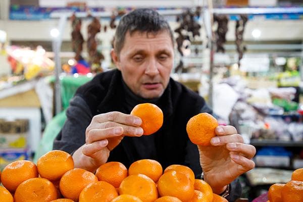 Un homme choisit des mandarines